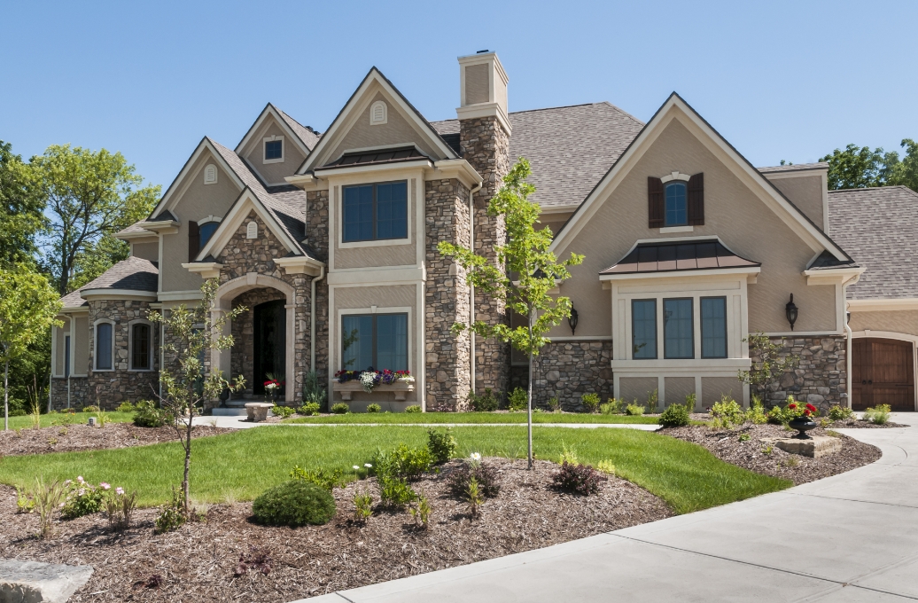Beautiful home on a green lawn on a sunny day. This is a hero image on the fiduciary law page of Roman & Boock website.
