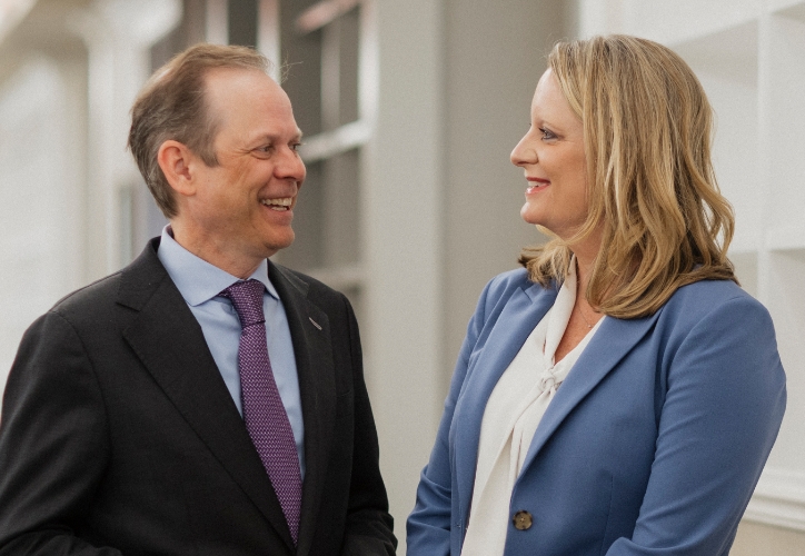 Attorneys Rachel Roman and Jamie Boock smile at one another.