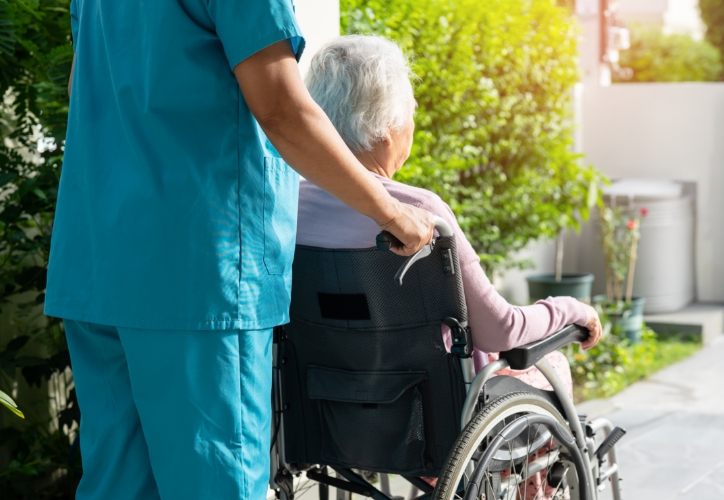 nurse pushing an elderly woman in a wheelchair