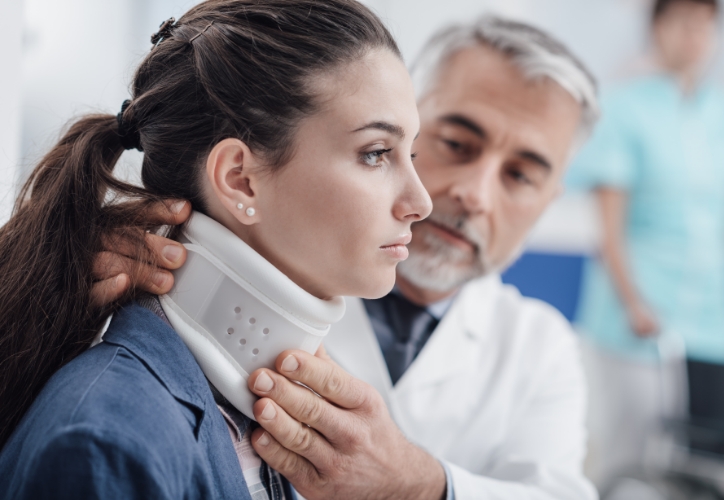 A doctor placing a neck brace on a patient after a trucking accident.