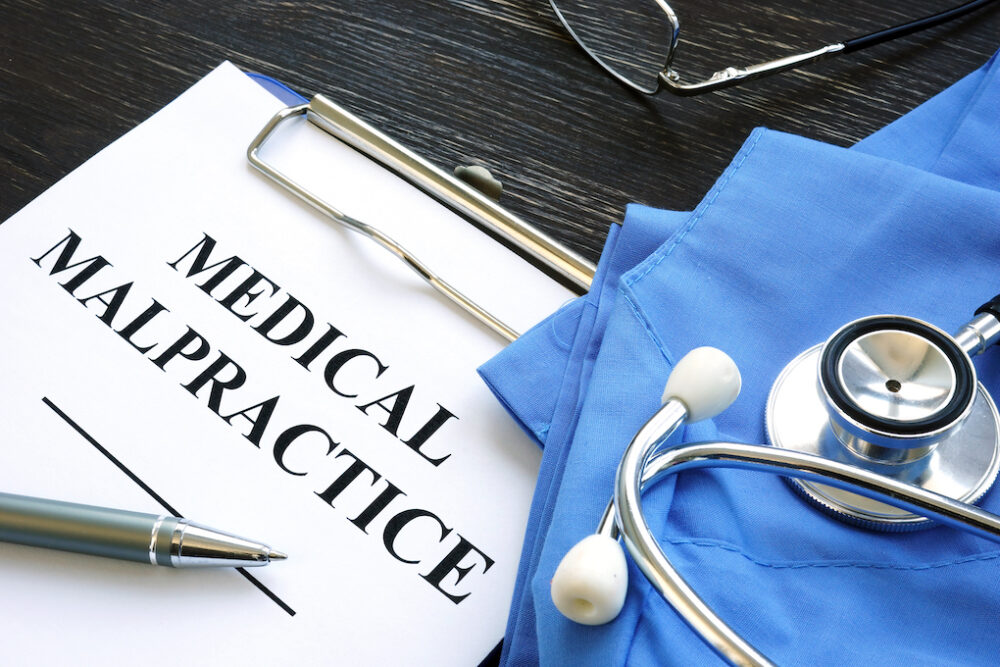 Medical malpractice case file with a Medical suit, stethoscope and documents.