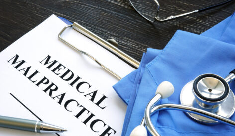 Medical malpractice case file with a Medical suit, stethoscope and documents.