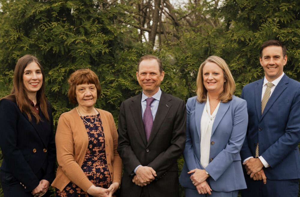 photo of five St. Louis attorneys in front of greenry