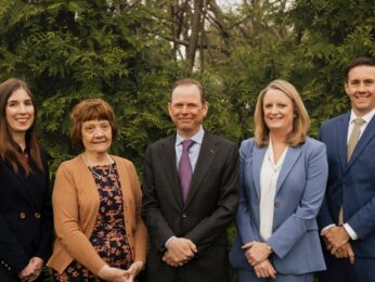 photo of five St. Louis attorneys in front of greenry
