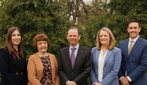 photo of five St. Louis attorneys in front of greenry