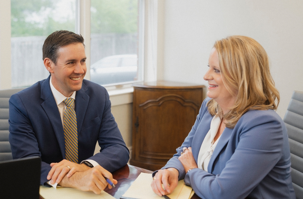 Two Roman & Boock attorneys discussing case processes.