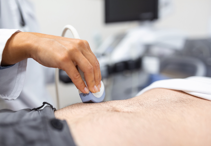 hand holding an ultrasound on a mans abdominal cavity