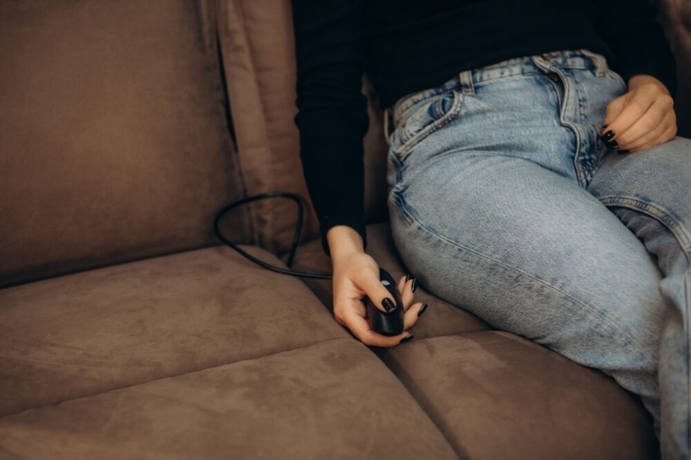 Hand holding a joystick on the couch.