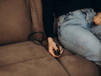 Hand holding a joystick on the couch.